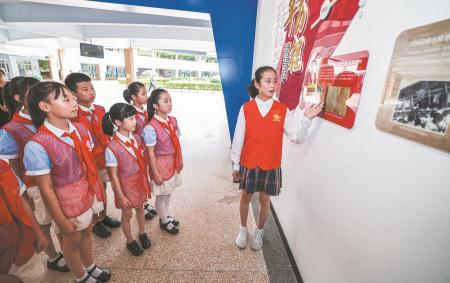 　　9月4日，在嘉兴市实验小学校史连廊间，全国优秀少先队员王希然（右一）为新一批红船小讲解讲述学校的百年校史，坚定“讲好学校故事、讲好国家故事”的使命担当。
　　新学期伊始，浙江省嘉兴市南湖区各中小学开启形式多样的以红色教育为主题的“开学第一课”。各校组织师生观看纪念中国人民抗日战争暨世界反法西斯战争胜利80周年大会，同时开展红色故事宣讲、红色课堂、诗朗诵、新四军老战士抗战事迹图片展等活动，带领学生重温烽火岁月、感悟伟大抗战精神，让红色基因深植青少年的心田，激发爱国情怀与民族自豪感。
　　新华社记者 徐昱 摄