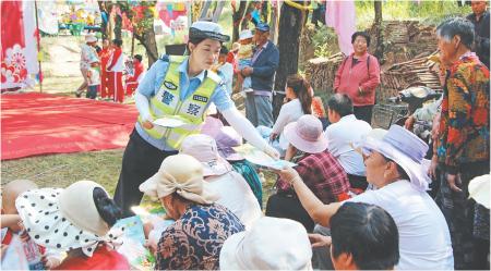 　　近日，临洮县公安局交警大队巧借农村庙会“大戏台”人流量聚集的有利契机，走进辖区新添镇开展“美丽乡村行”交通安全巡回宣讲活动。图为宣传民警为现场群众发放交通安全宣传资料。                      杨小娟 摄
